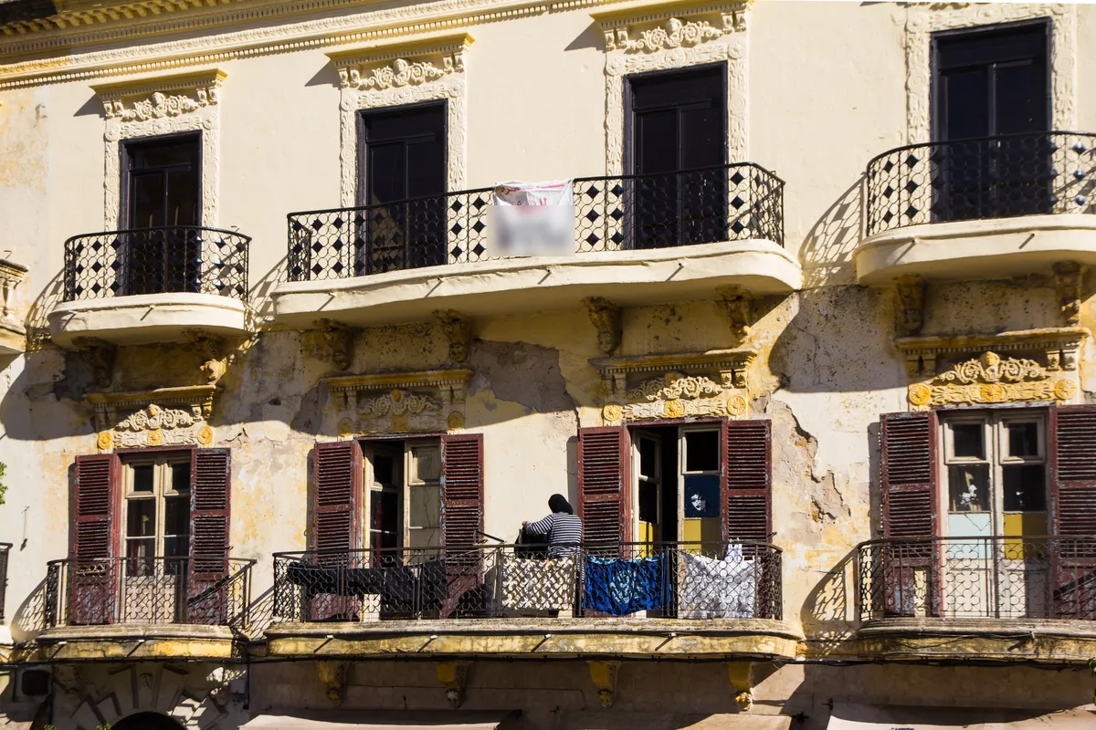 Façade d'un immeuble ancien à balcons rue d'Italie à Tanger, avec une banderole sur un balcon
