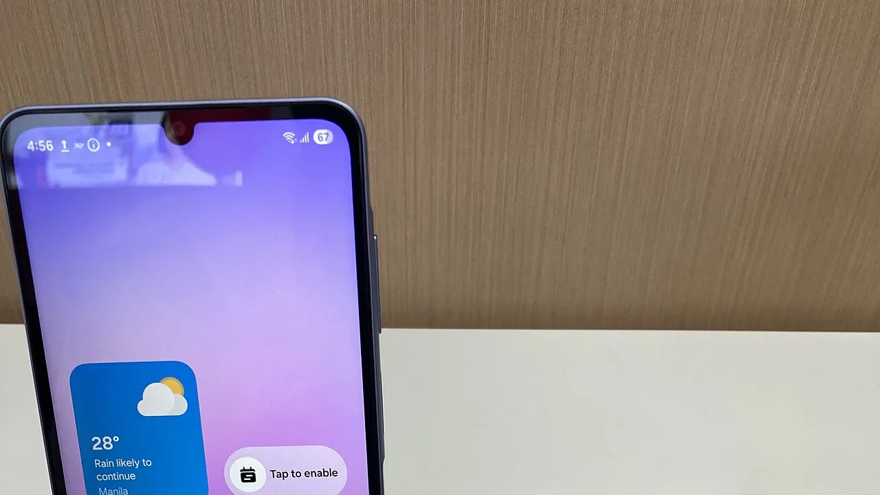Galaxy A07 allumé sur un présentoir en magasin, devant un mur en bois