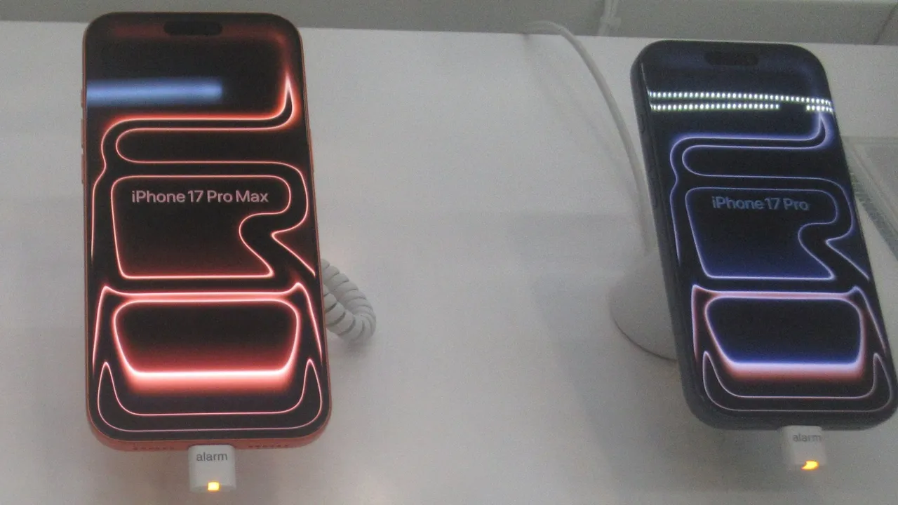 iPhone 17 Pro Max orange cosmique et iPhone 17 Pro bleu intense exposés sur une table de démonstration en magasin