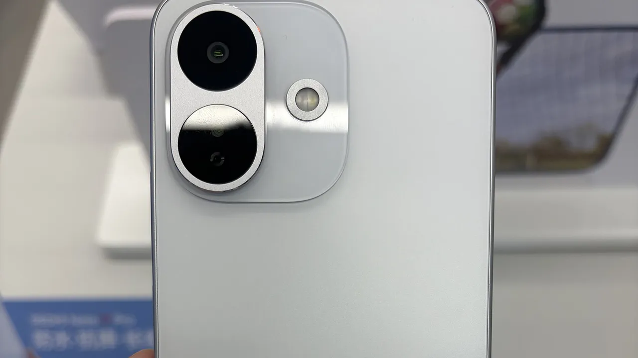 Dos argenté d'un Redmi Note 17 Pro (version chinoise) tenu en main dans un magasin Xiaomi, avec son double module photo